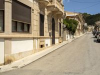 a building with lots of windows is on the side of a road in a narrow alley