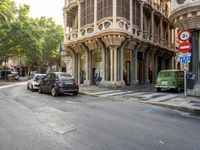 a street scene with a car parked along side the road and a building near by