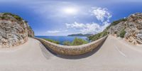 an image of the mountain with a curved road on it's sides and the sea in the distance