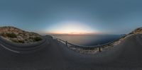 the view from a fish eye lens at sunset of a winding road leading to a small harbor