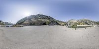 a very large hill sitting on top of a lush green hillside side valley as the sun shines over the sea