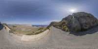 a 360 - image of a person riding a skateboard at a mountain top side