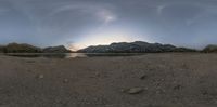 view from below a panoramic of a small lake in the middle of a desert plain