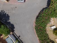 an overhead view of some small street cars, bushes, and plants with a name written on them