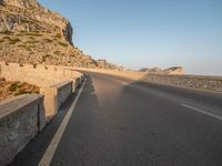 the road leads out onto a large cliff behind it and is empty at both sides of the road