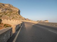 the road leads out onto a large cliff behind it and is empty at both sides of the road