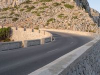 a motorcycle parked by a mountain cliff in italy that is the middle of the road