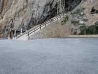 a stone staircase goes down a small, steep mountain in this picture by the road