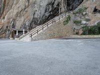 a stone staircase goes down a small, steep mountain in this picture by the road