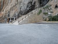 a stone staircase goes down a small, steep mountain in this picture by the road