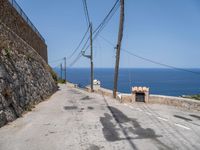 there is a stone wall that separates the street by the sea and two trucks are parked next to it