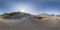 a 360 - view is being taken of a hill and lighthouse seen through a fish eye lens