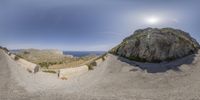 this is an image of a panoramic view of a mountain with rocks and grass