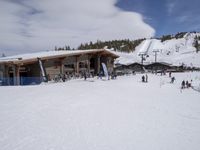 several skiers standing in front of the lodge on a snowy day, the lodge is covered with tall pines and snow
