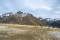 a man with his bicycle in a mountainous area in winter time, riding on a mountain side