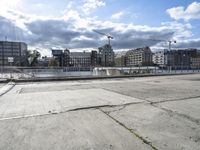 a man on a city waterfront with buildings behind him and one person walking away from the other