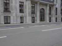 a man wearing a helmet and holding a red frisbee crossing the street in front of a building