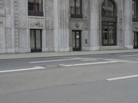 a man wearing a helmet and holding a red frisbee crossing the street in front of a building