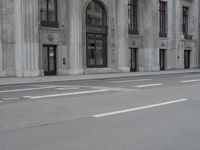 a man wearing a helmet and holding a red frisbee crossing the street in front of a building