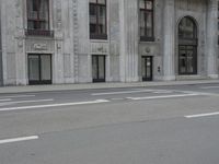 a man wearing a helmet and holding a red frisbee crossing the street in front of a building