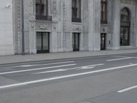 a man wearing a helmet and holding a red frisbee crossing the street in front of a building