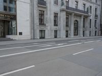 a man wearing a helmet and holding a red frisbee crossing the street in front of a building