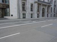 a man wearing a helmet and holding a red frisbee crossing the street in front of a building