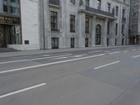 a man wearing a helmet and holding a red frisbee crossing the street in front of a building