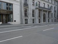 a man wearing a helmet and holding a red frisbee crossing the street in front of a building