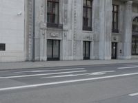 a man wearing a helmet and holding a red frisbee crossing the street in front of a building