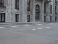 a man wearing a helmet and holding a red frisbee crossing the street in front of a building