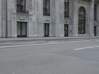 a man wearing a helmet and holding a red frisbee crossing the street in front of a building