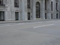 a man wearing a helmet and holding a red frisbee crossing the street in front of a building