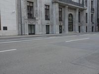 a man wearing a helmet and holding a red frisbee crossing the street in front of a building