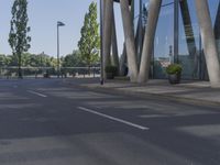 a man on a red skateboard rides by a building by the water near trees