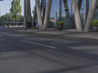 a man on a red skateboard rides by a building by the water near trees