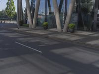 a man on a red skateboard rides by a building by the water near trees