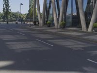 a man on a red skateboard rides by a building by the water near trees