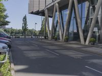 a man on a red skateboard rides by a building by the water near trees