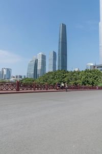 a man riding his bike on a street near buildings and trees in shanghai, china