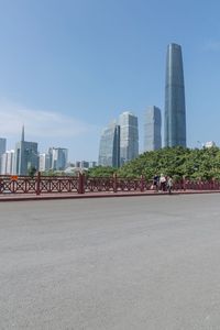 a man riding his bike on a street near buildings and trees in shanghai, china