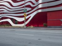 a man riding a bike in front of a building with red, white and silver stripes