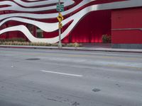 a man riding a bike in front of a building with red, white and silver stripes