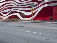 a man riding a bike in front of a building with red, white and silver stripes