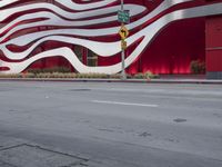 a man riding a bike in front of a building with red, white and silver stripes