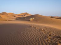 a man is riding a horse in the desert at sunset time near dunes that are covered with sand