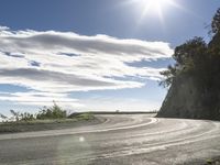 a man on his motorcycle rides along an empty road in the sunlight and it looks nice