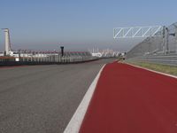 a man is riding his motorcycle on the track behind the fence and gate to the other side