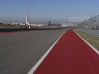 a man is riding his motorcycle on the track behind the fence and gate to the other side