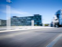 a man is riding a skateboard down the road in front of some large buildings